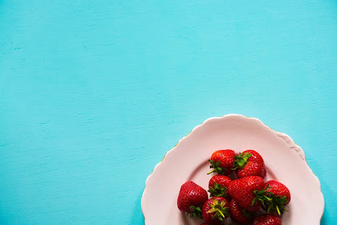 Strawberries on plate with blue background